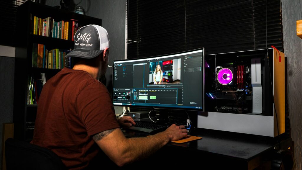 Editor de vídeo trabajando ante una pantalla de montaje en un estudio de producción audiovisual.