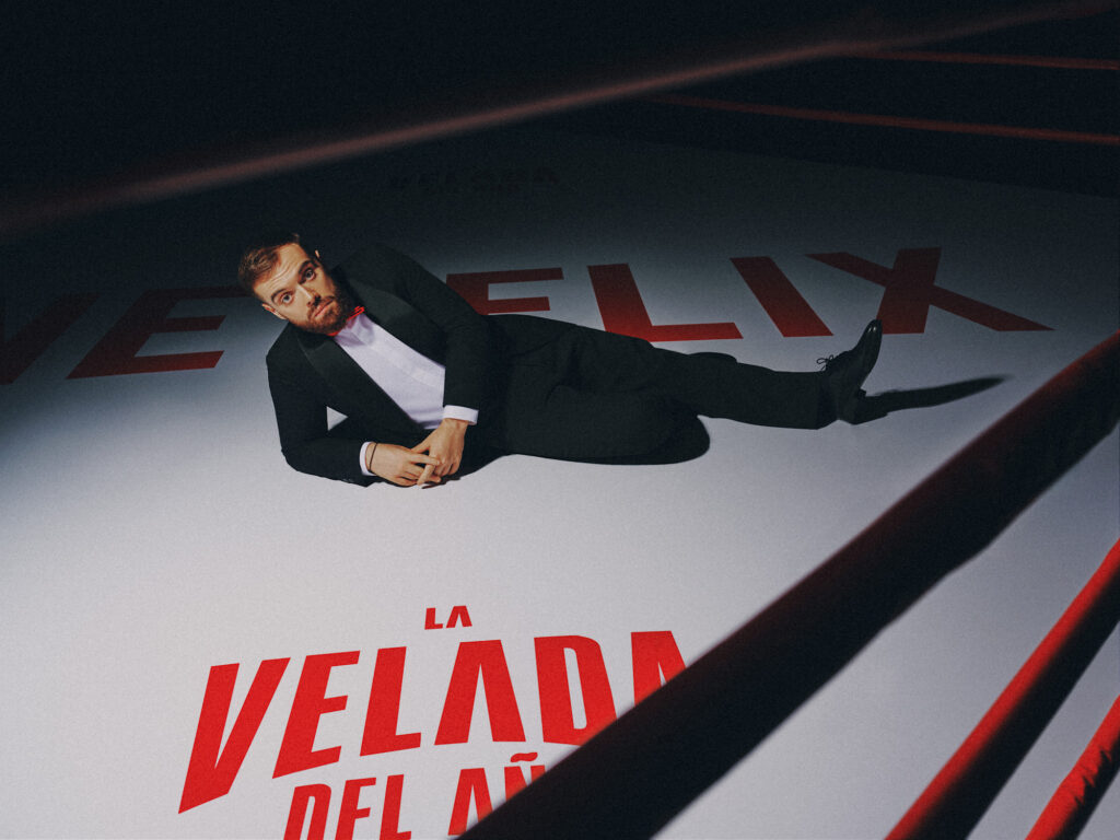 Ibai Llanos sobre el ring con los logotipos de Netflix y La Velada del Año. Imagen oficial del anuncio.